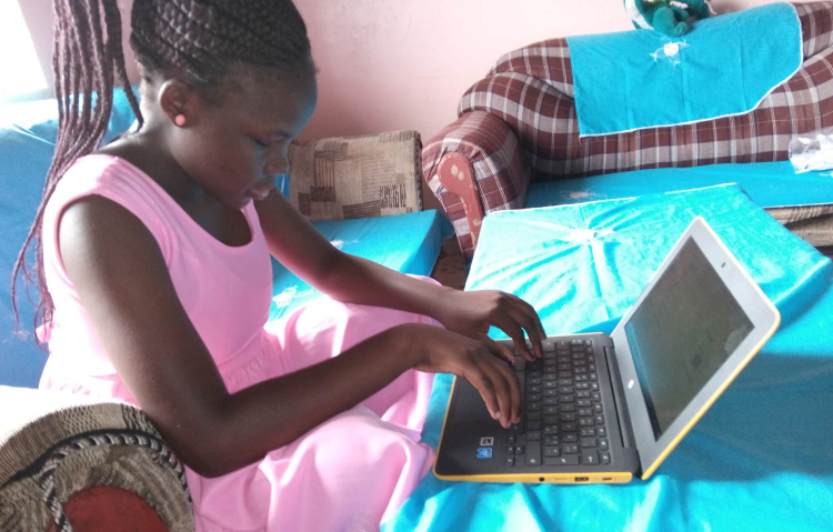 A young female student using a Chrmebook laptop at home