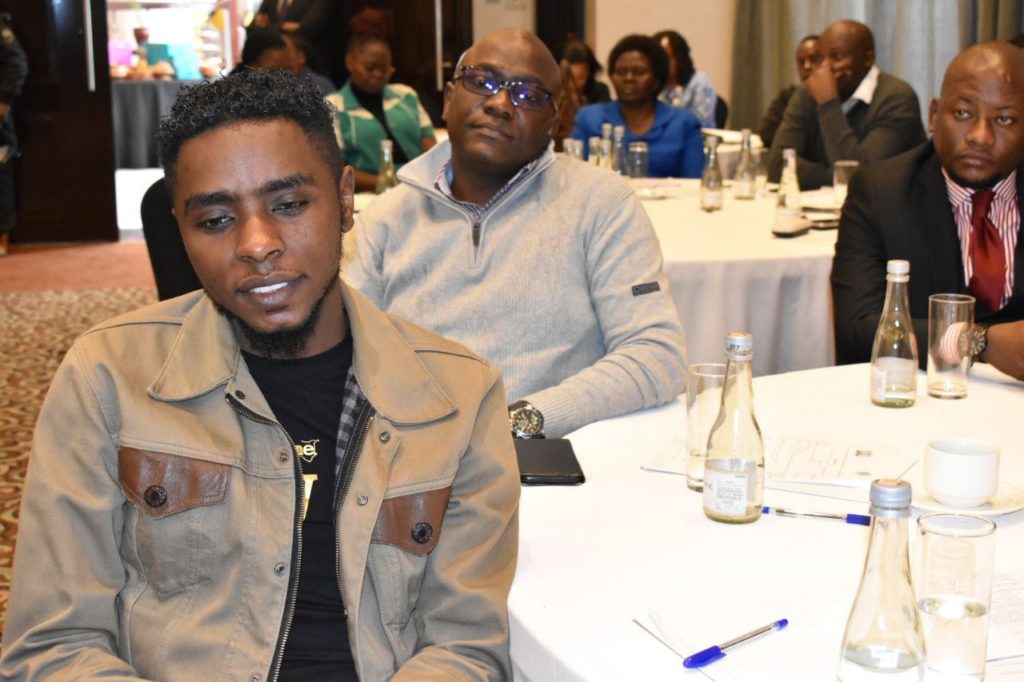 A picture of Julius Mbura (Advocacy Officer - inABLE) and George Siso (Business Development Manager - inABLE) seated at a table listening to the launch of the Disability Mainstreaming Status report.