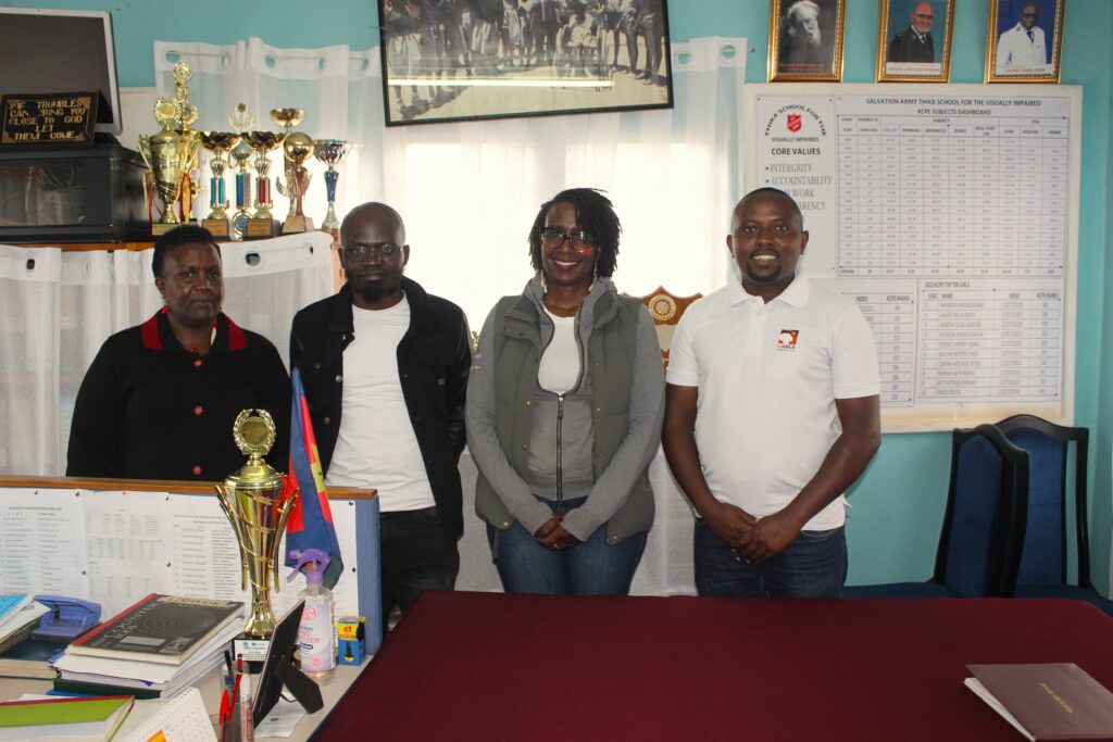 A picture of Mrs. Penina Mutuku, Anthony Njoroge and Microsoft staff posing for a picture inside Mrs. Penina's office.