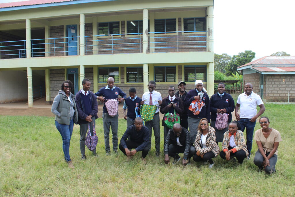 A picture of Thika High School students, Microsoft staff and inABLE staff, smiling and posing for a picture. The students are holding gift bags.