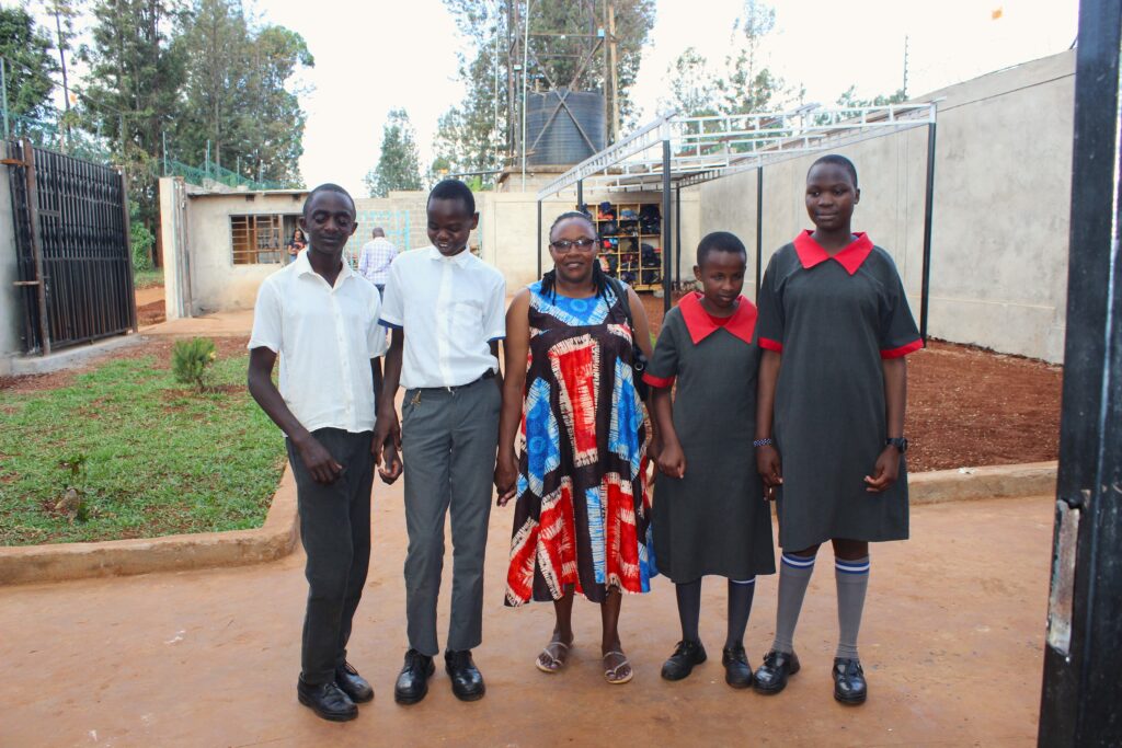 A picture of a teacher and four students smiling and posing for a picture at Kang'aru Digital Hub 