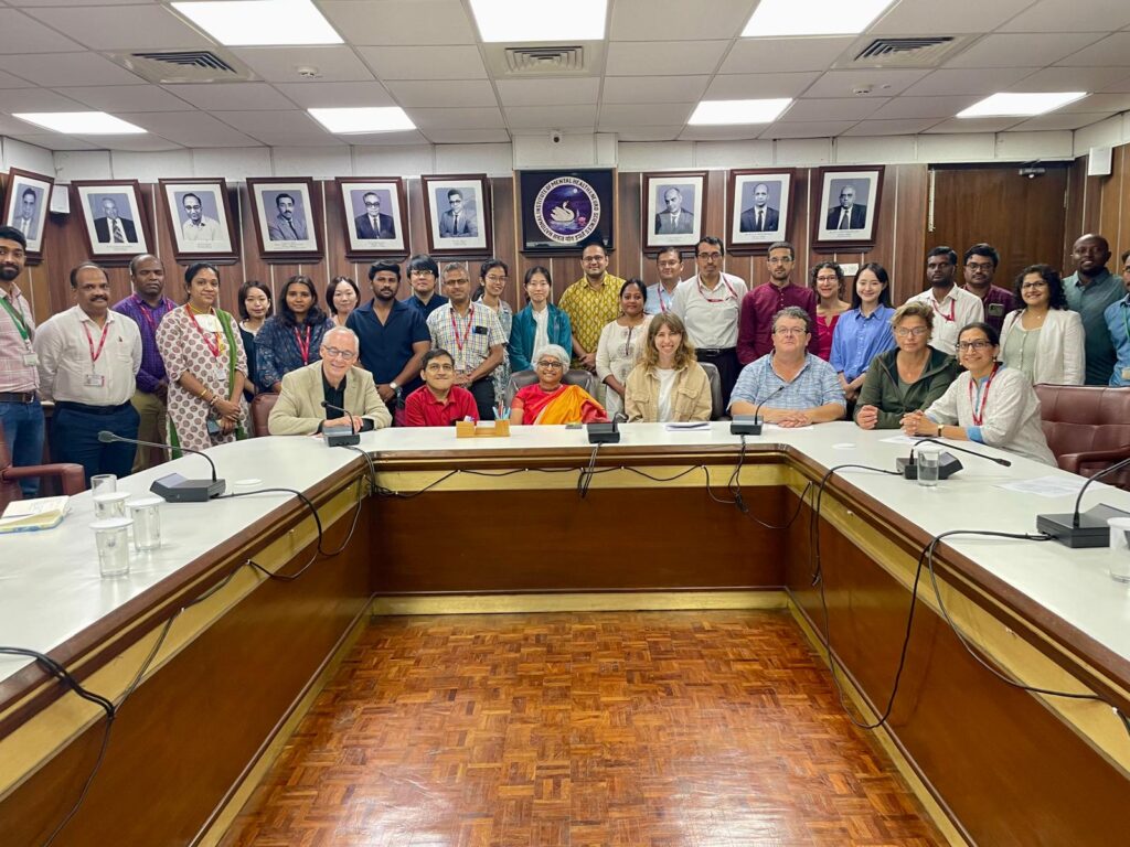 This is a picture of the International delegation at the National Institute of Mental Health and Neuroscience in Bangalore. It includes Anthony Njoroge and Klaus Hoeckner. Everyone is smiling and posing for a picture.