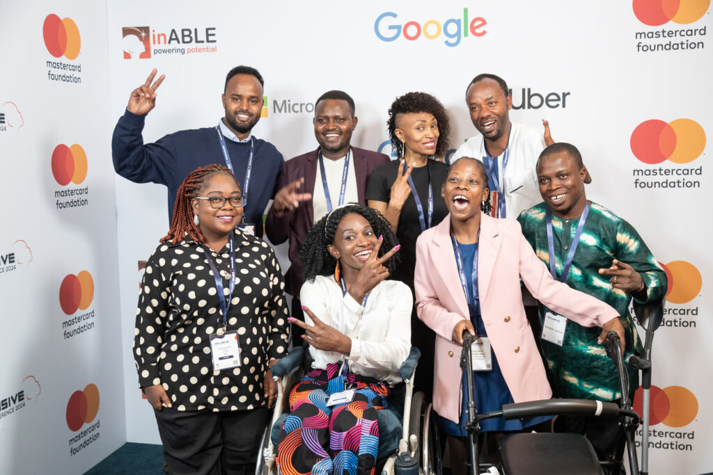 An image that includes people with diverse disabilities, smiling and posing for a picture.