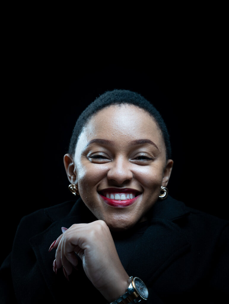 A picture of Mumsie smiling while wearing a stylish black jacket, exuding warmth and confidence.